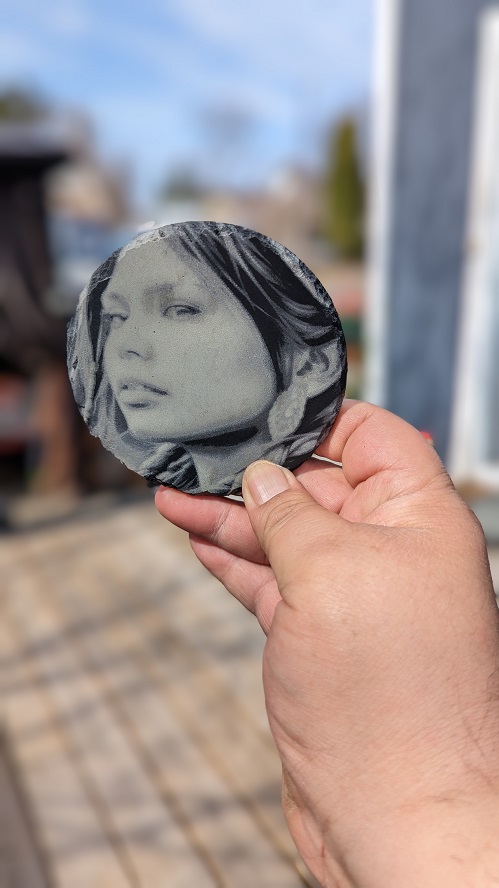 Round slate coaster engraved with a woman's photo portrait