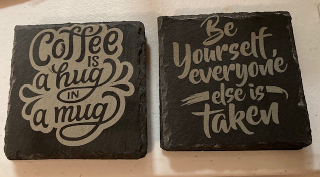 Slate tile coaster engraved with the phrase coffee is a hug in a mug