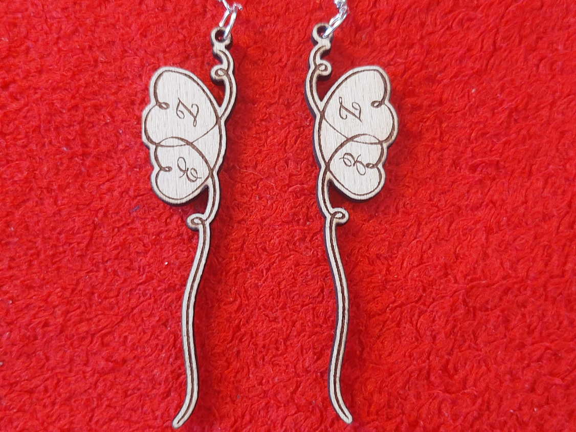 A pair of earrings shaped around a heart and ribbon motif with initials