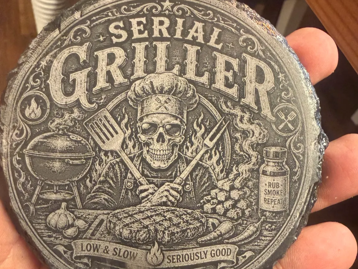 Skull wearing a chef hat grilling illustration engraved on slate coaster