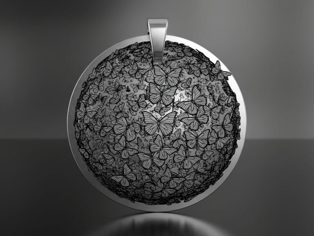 A round metal keychain engraved with an intricate butterfly mandala