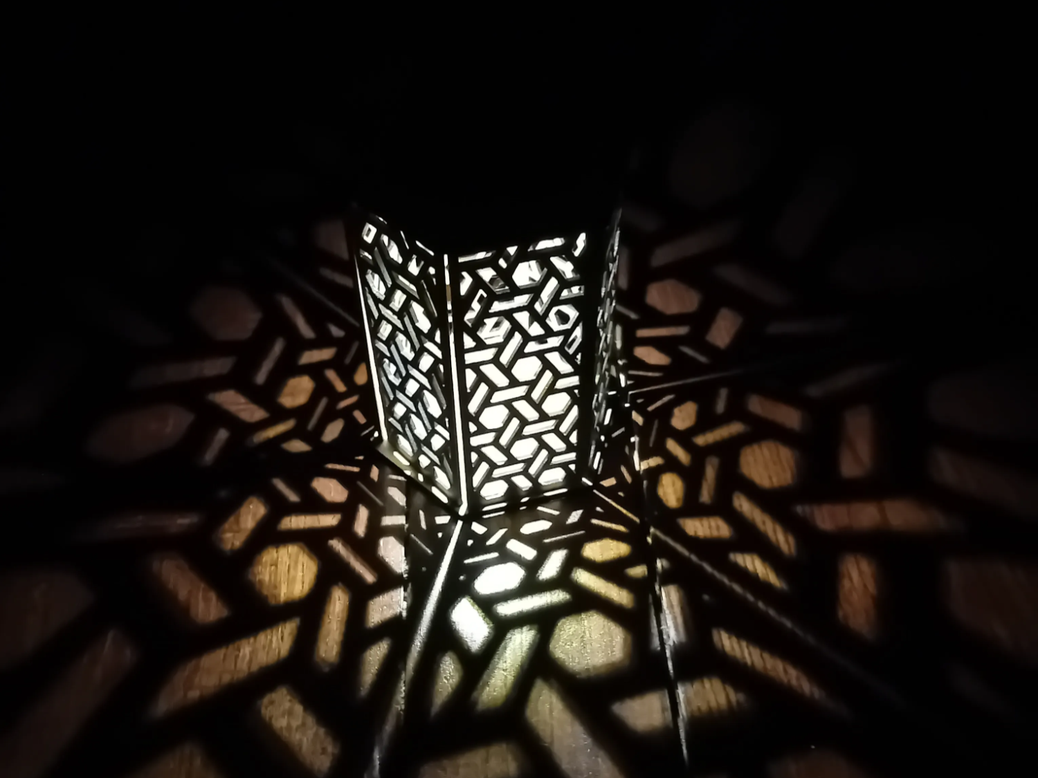 Hexagonal laser cut solar charging lantern glowing and casting patterns outdoor light idea
