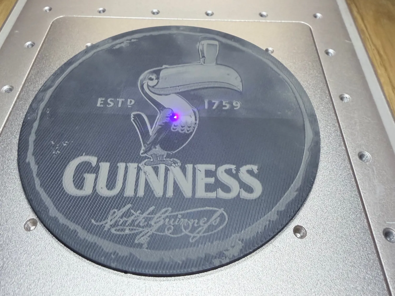 Coaster engraved with Guinness-inspired harp and lettering design