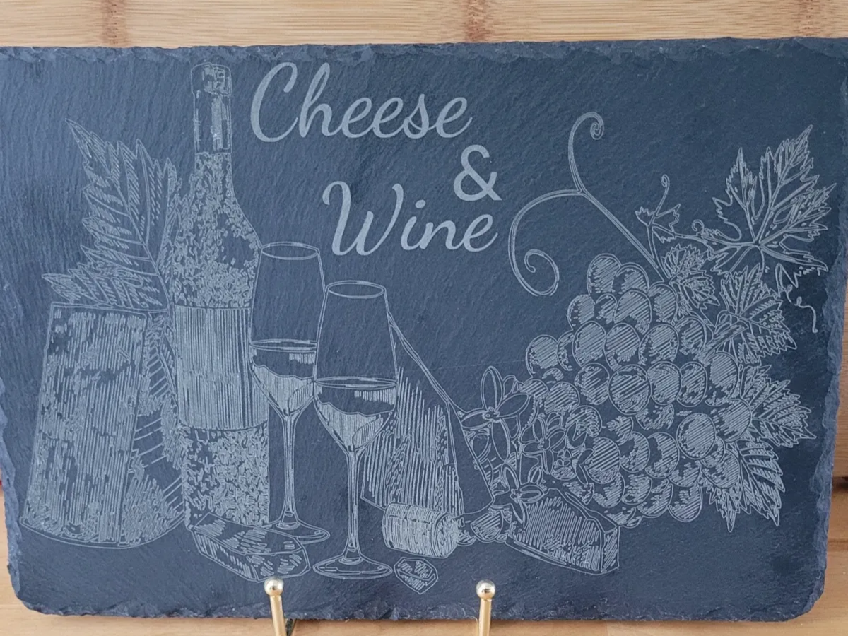 Plateau de service rectangulaire en ardoise gravé d'un motif de bouteille de vin, de verres, de fromage et de raisins portant l'inscription Cheese and Wine