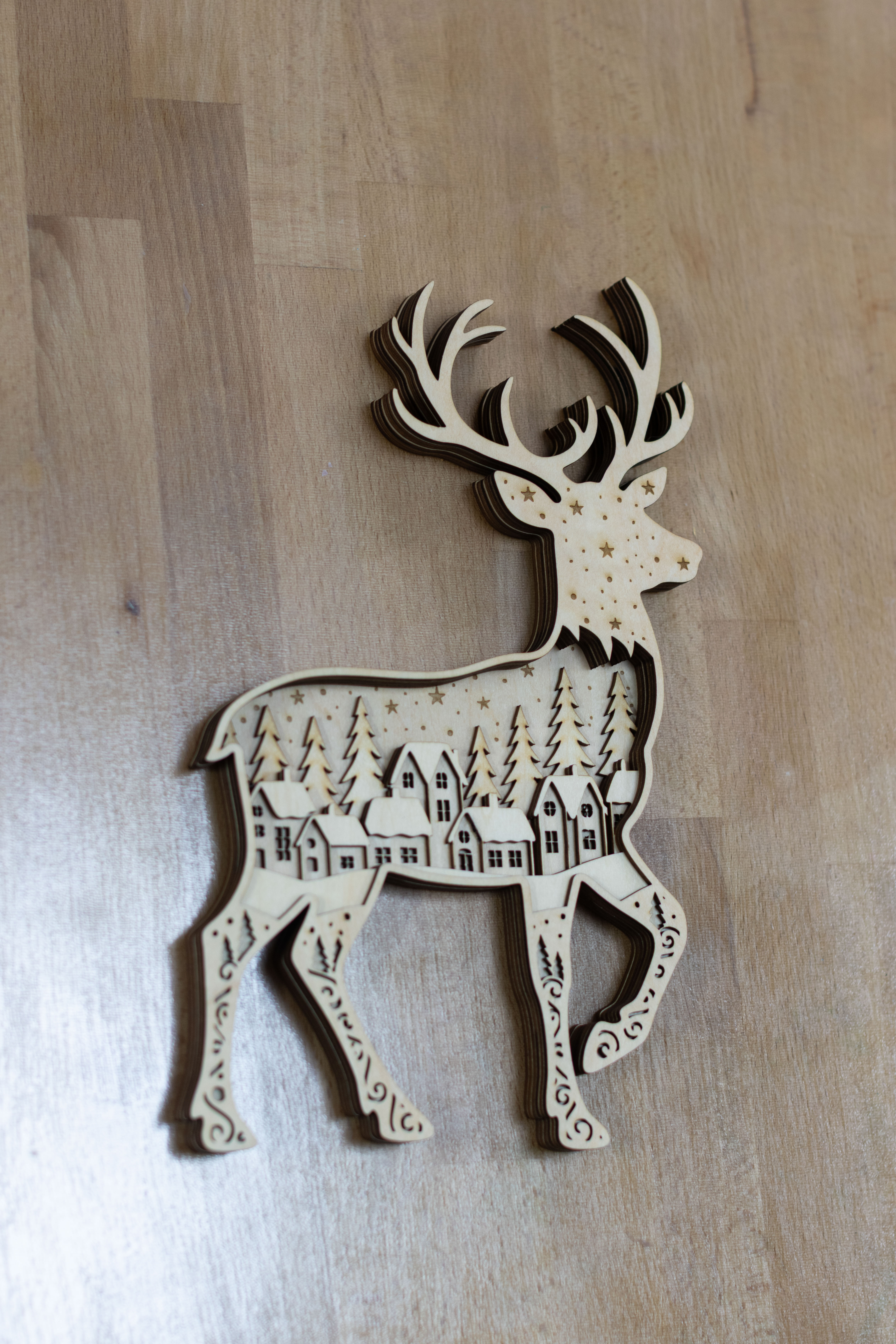 村のシーンがある多層レーザー切断木製トナカイのクリスマス ornament