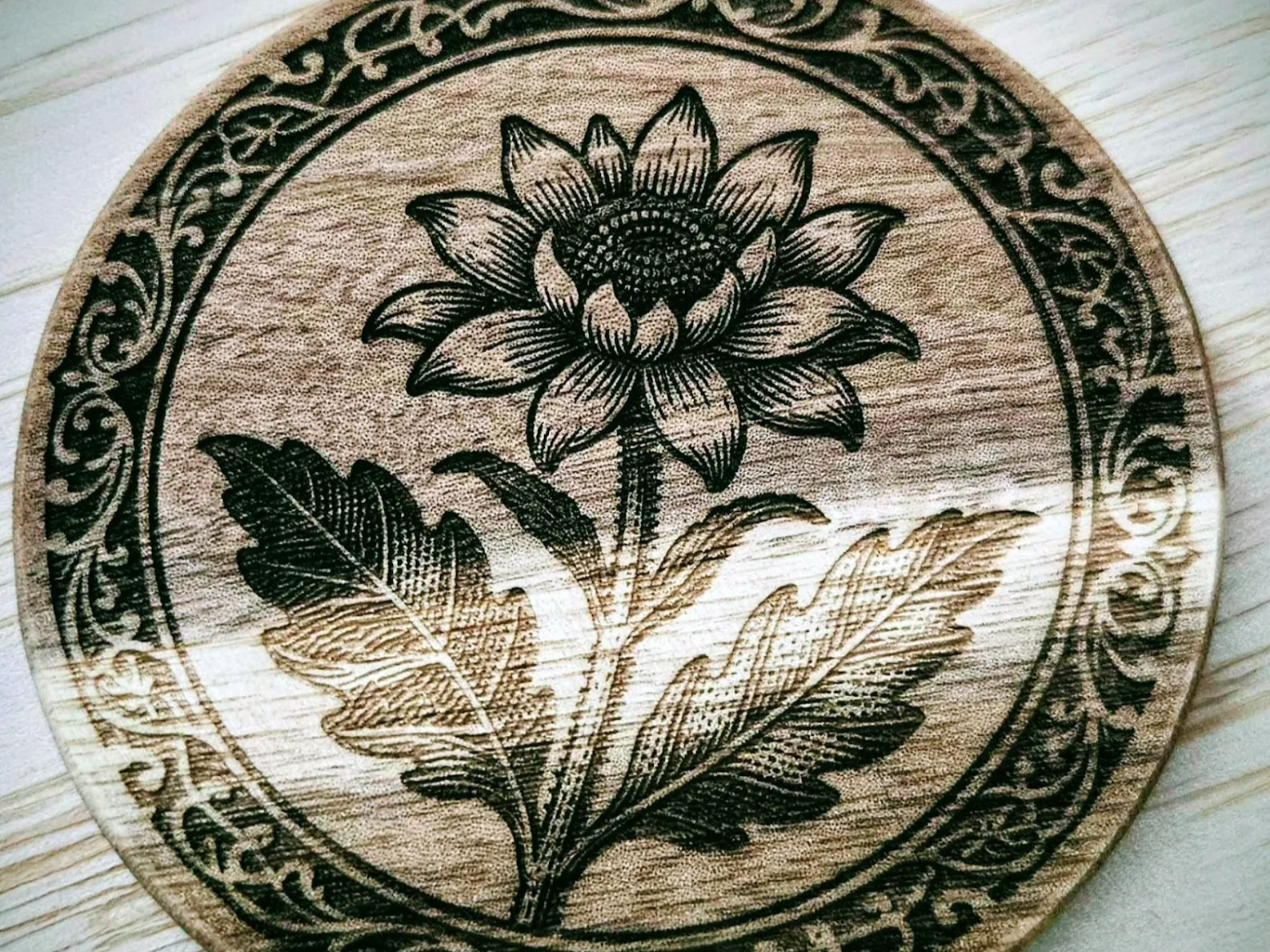 Wooden coaster with a floral center and decorative border