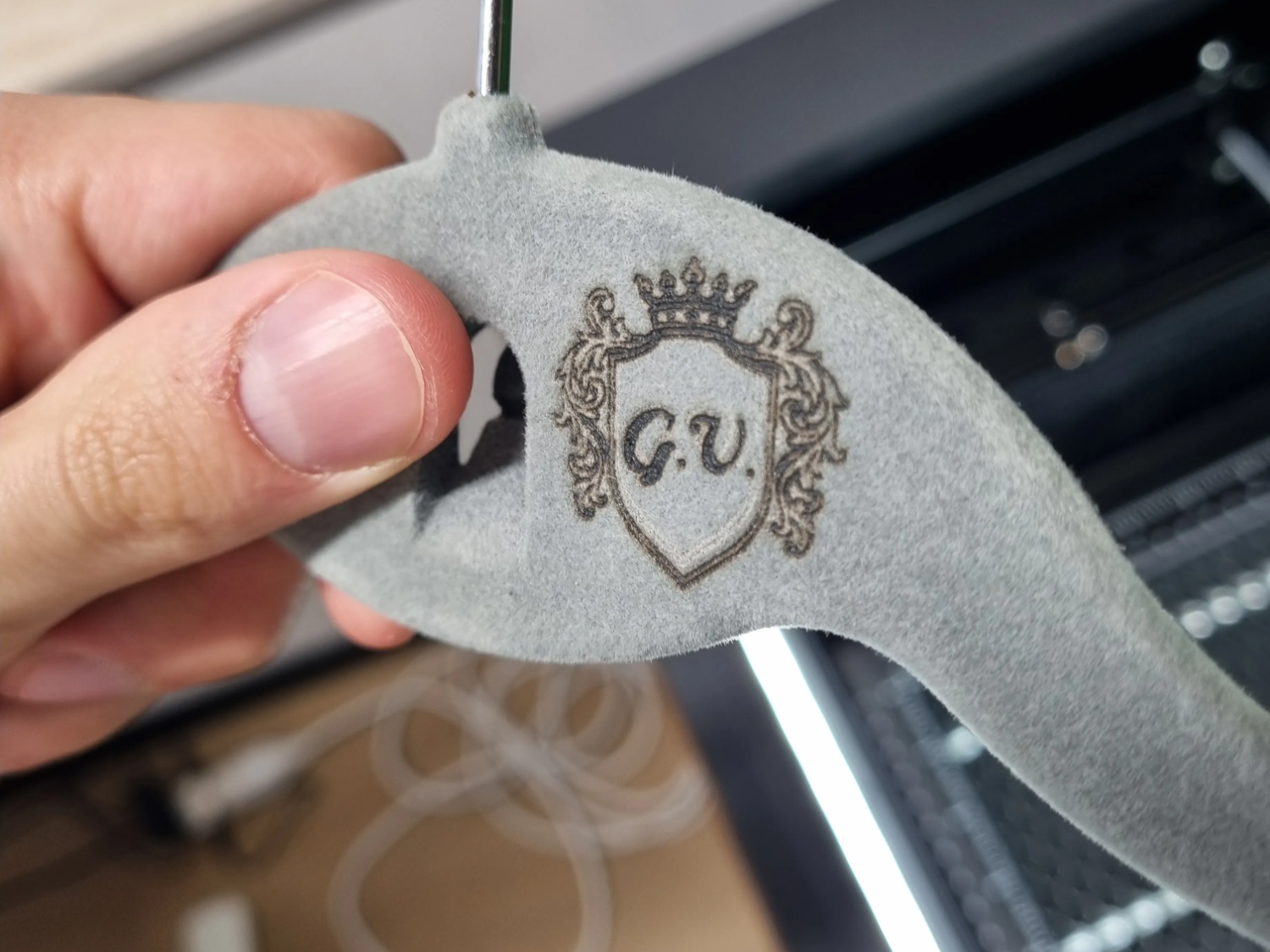 A velvet clothing hanger with a monogram added to the hook area