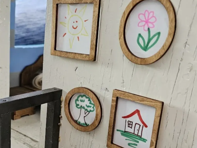 Gallery wall rumah boneka miniatur dengan foto berbingkai kecil