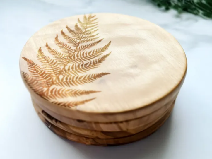 Engraved Fern Coaster Set laser cut design on a table
