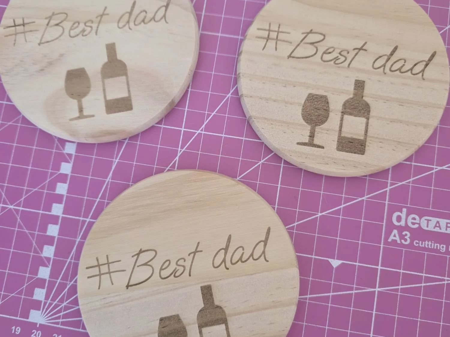 Set de dessous-de-verre ronds en bois gravés d'une icône de bouteille et de verre à vin et du texte Best Dad