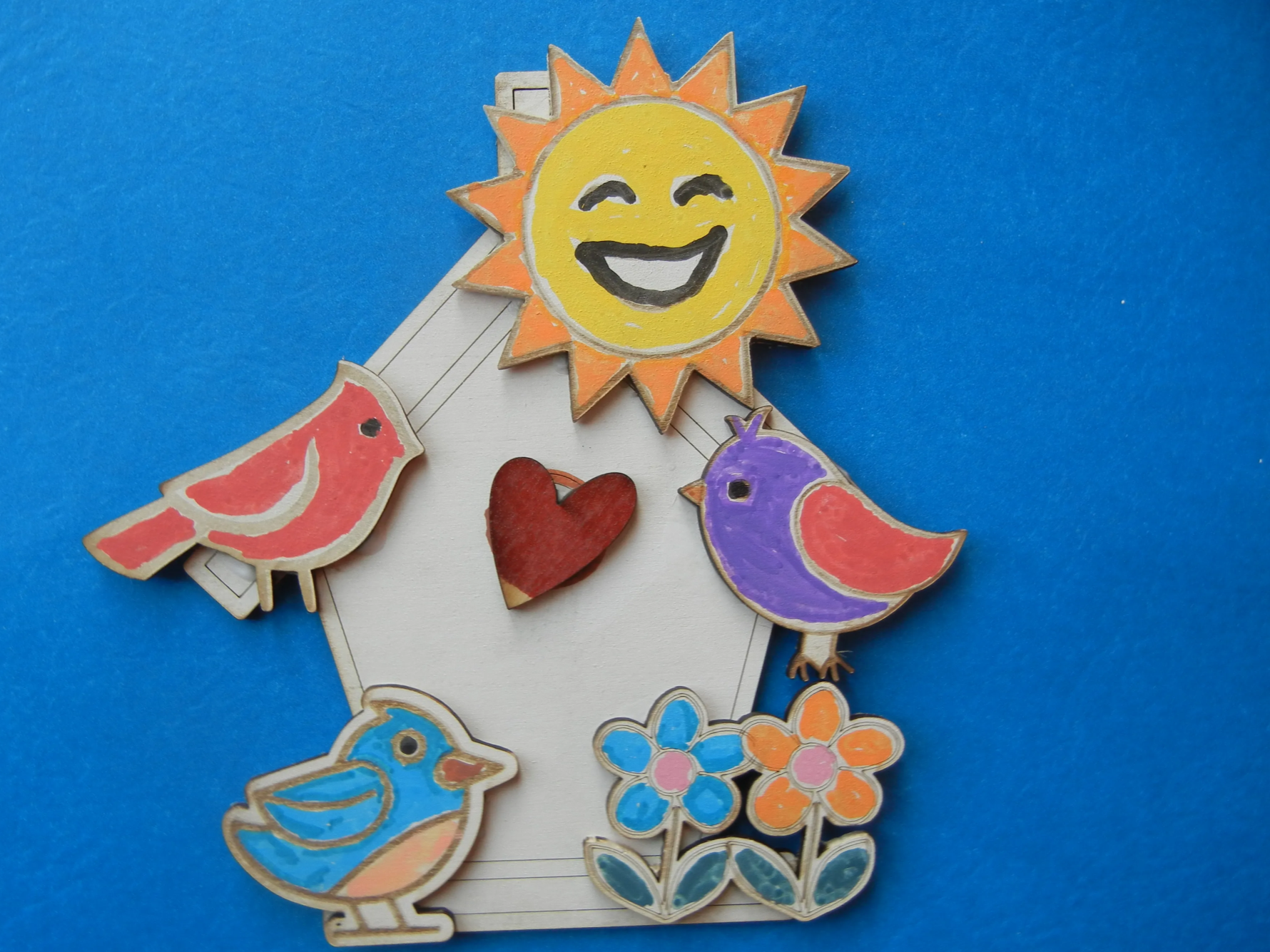 Nichoir coloré avec oiseaux, cœur, soleil et fleurs