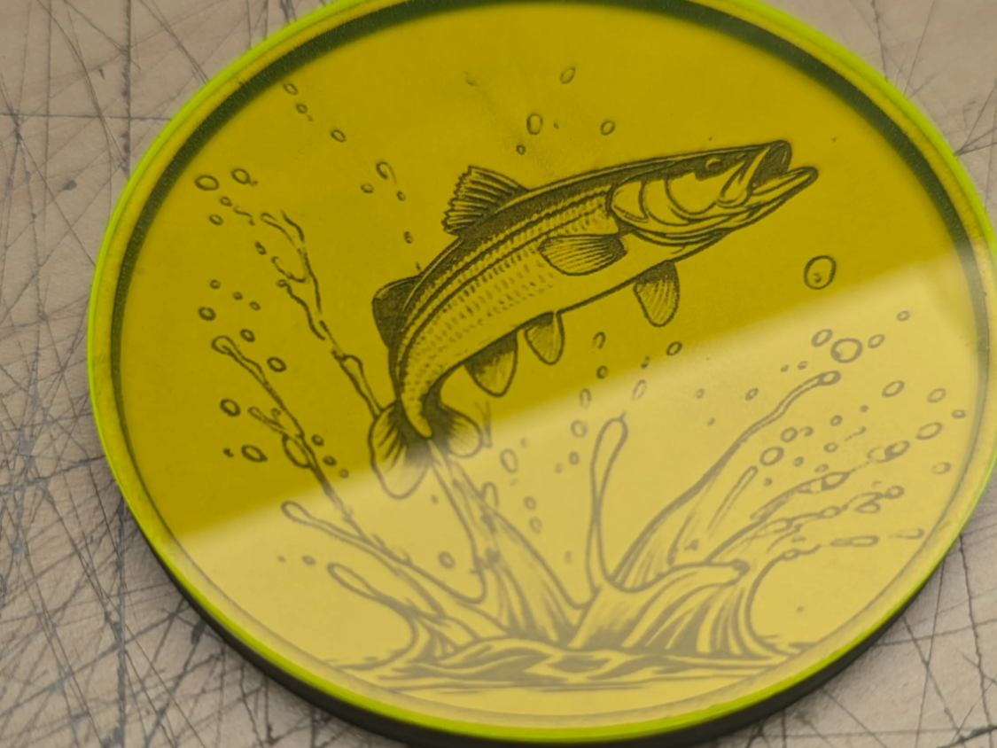 Gelber runder Untersetzer mit Illustration eines springenden Fisches