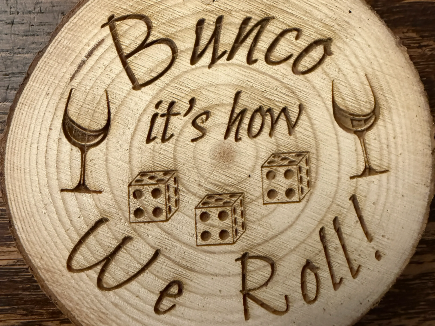 Dessous-de-verre rond en tranche de bois gravé de deux verres à vin et de dés pour une soirée jeu de bunco