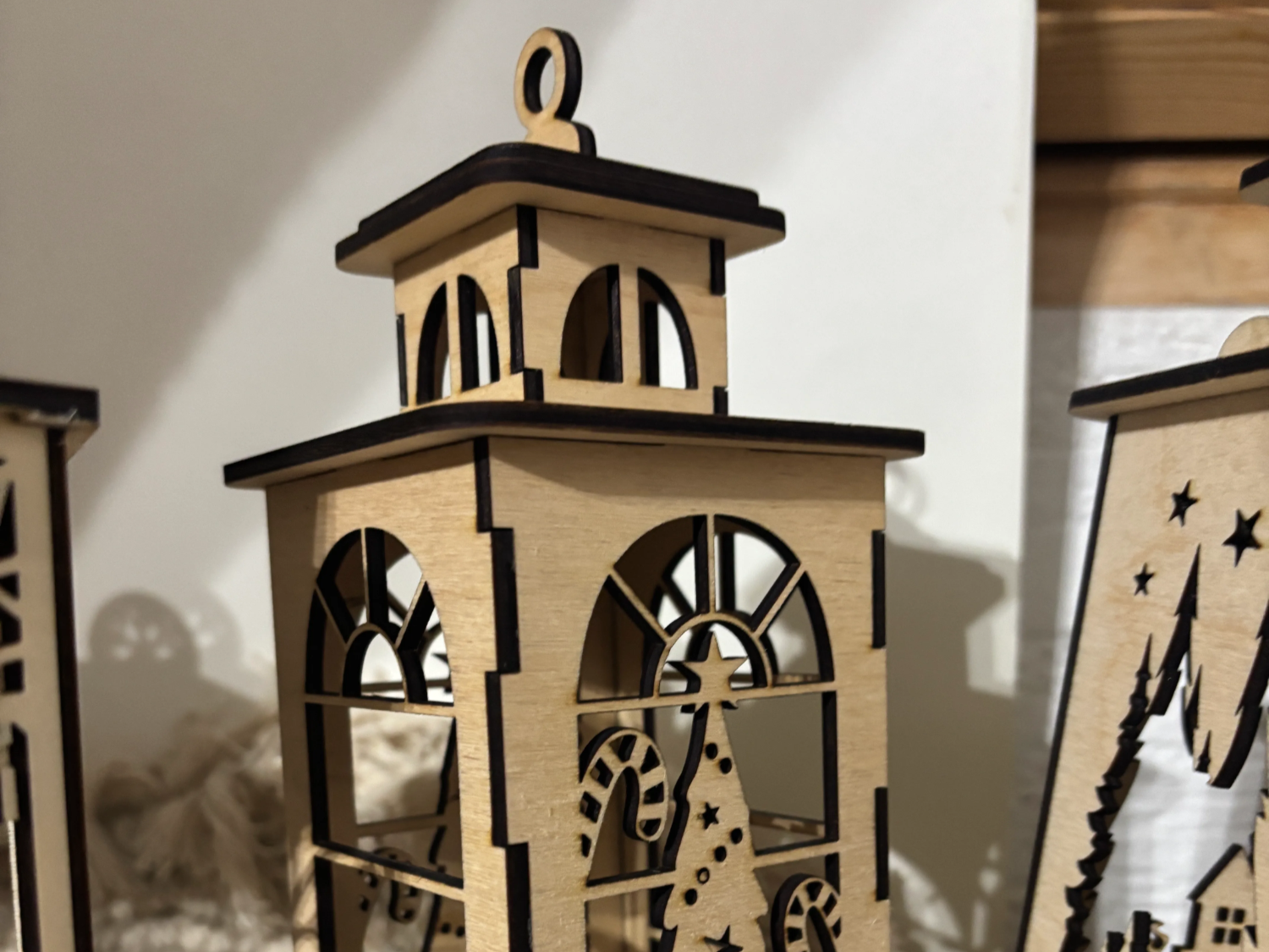 Lentera kayu dengan potongan bertema Natal yang menyala untuk dekorasi teras luar