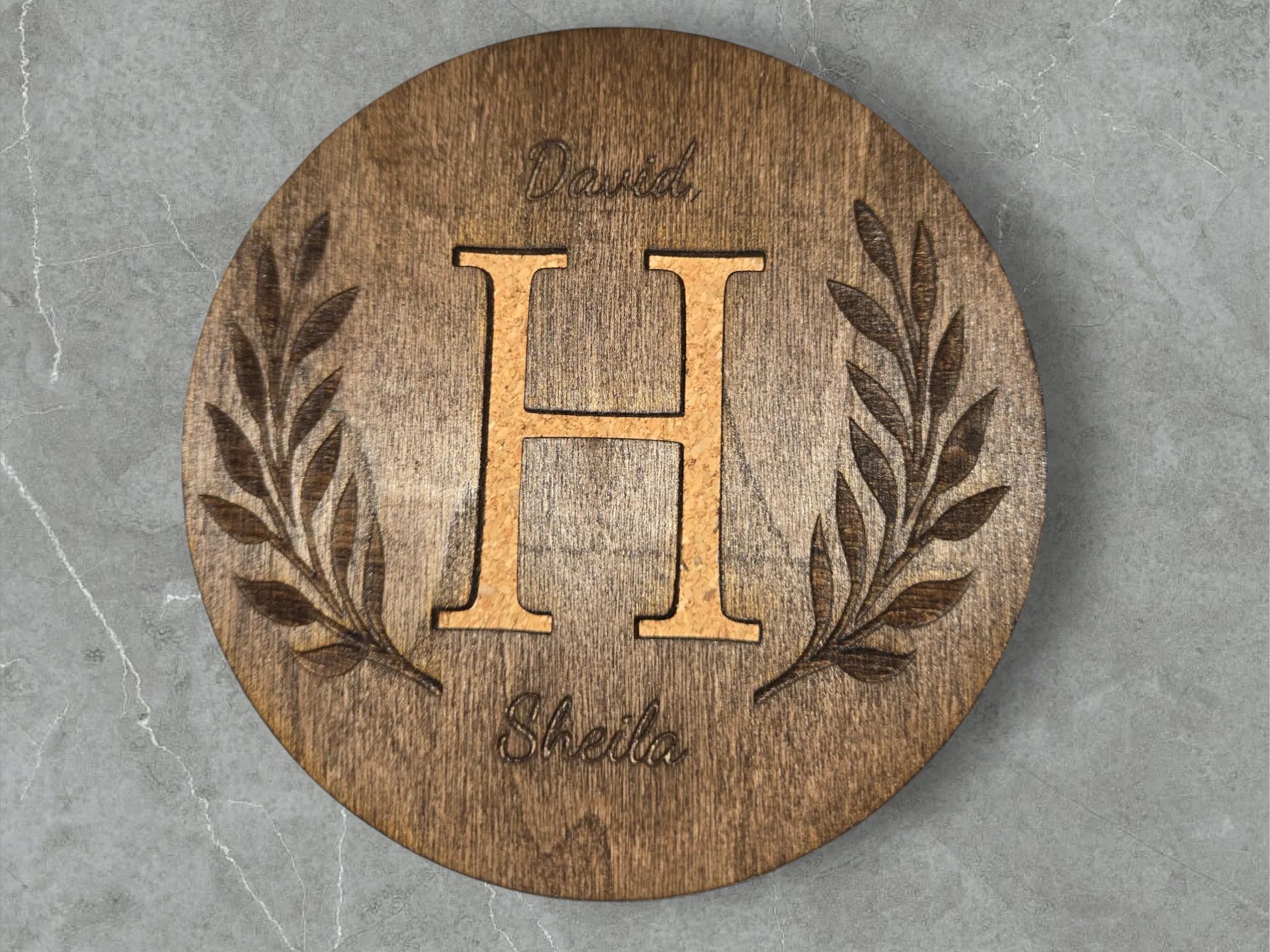 A wood coaster with a monogram cut all the way through