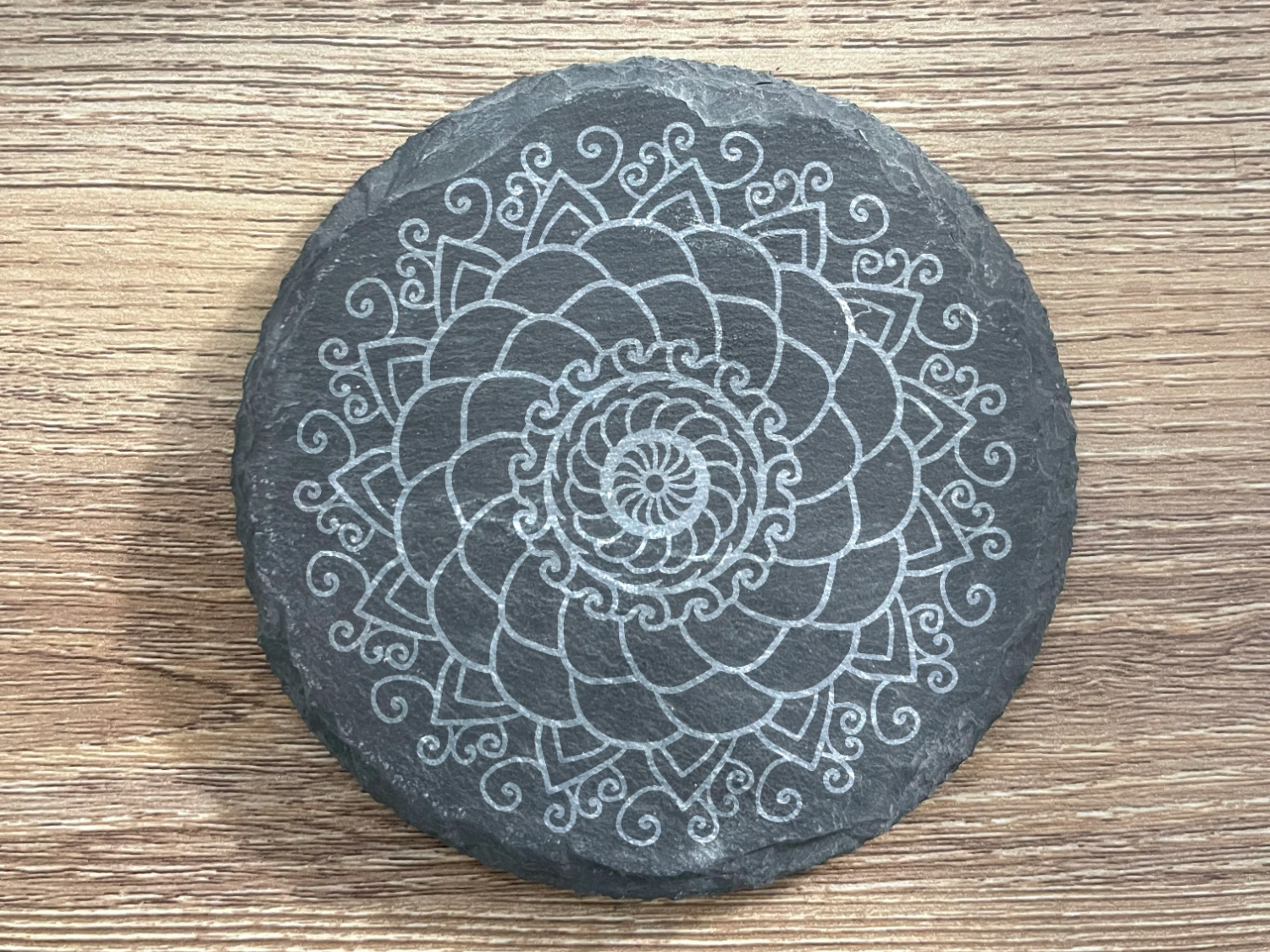 Intricate mandala design on circular slate coaster mandala craft idea