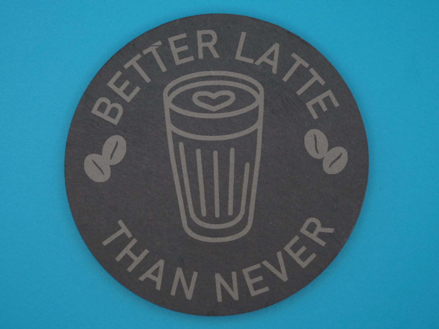 Coffee coaster engraved with Better Latte Than Never quote