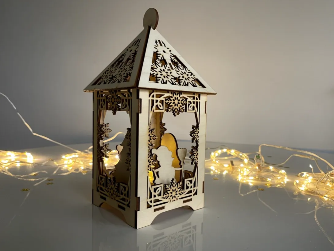 Open sided wooden Christmas lantern with fretted roof lit by fairy lights outdoor light idea