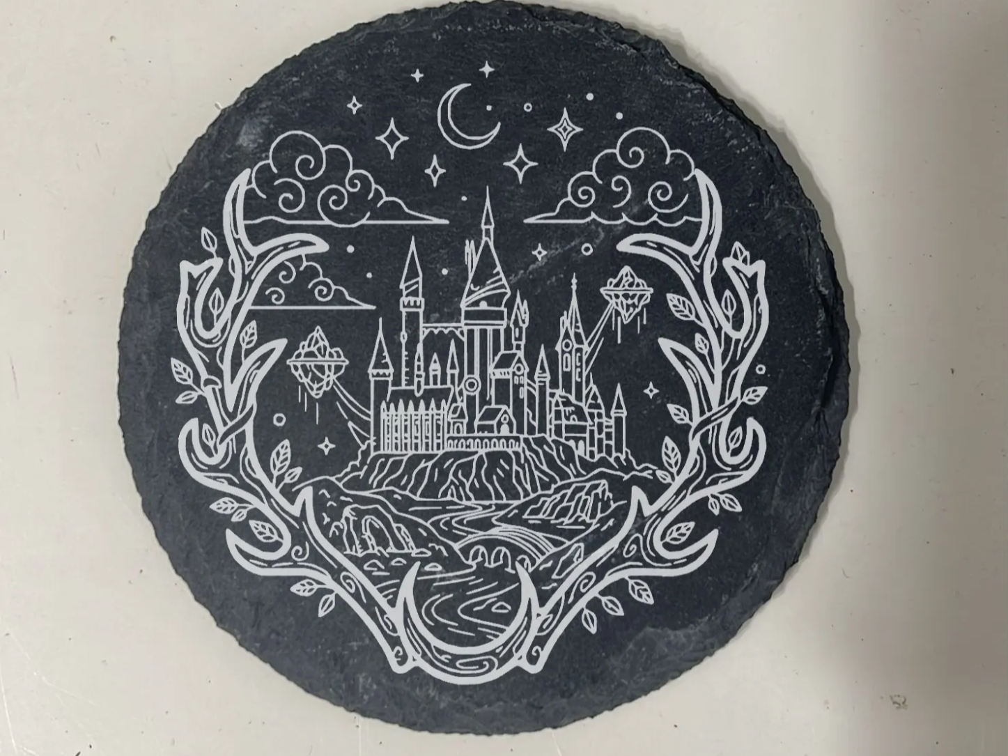 Runder Schiefer-Untersetzer mit gravierter Nachtszene aus Schloss und Mond
