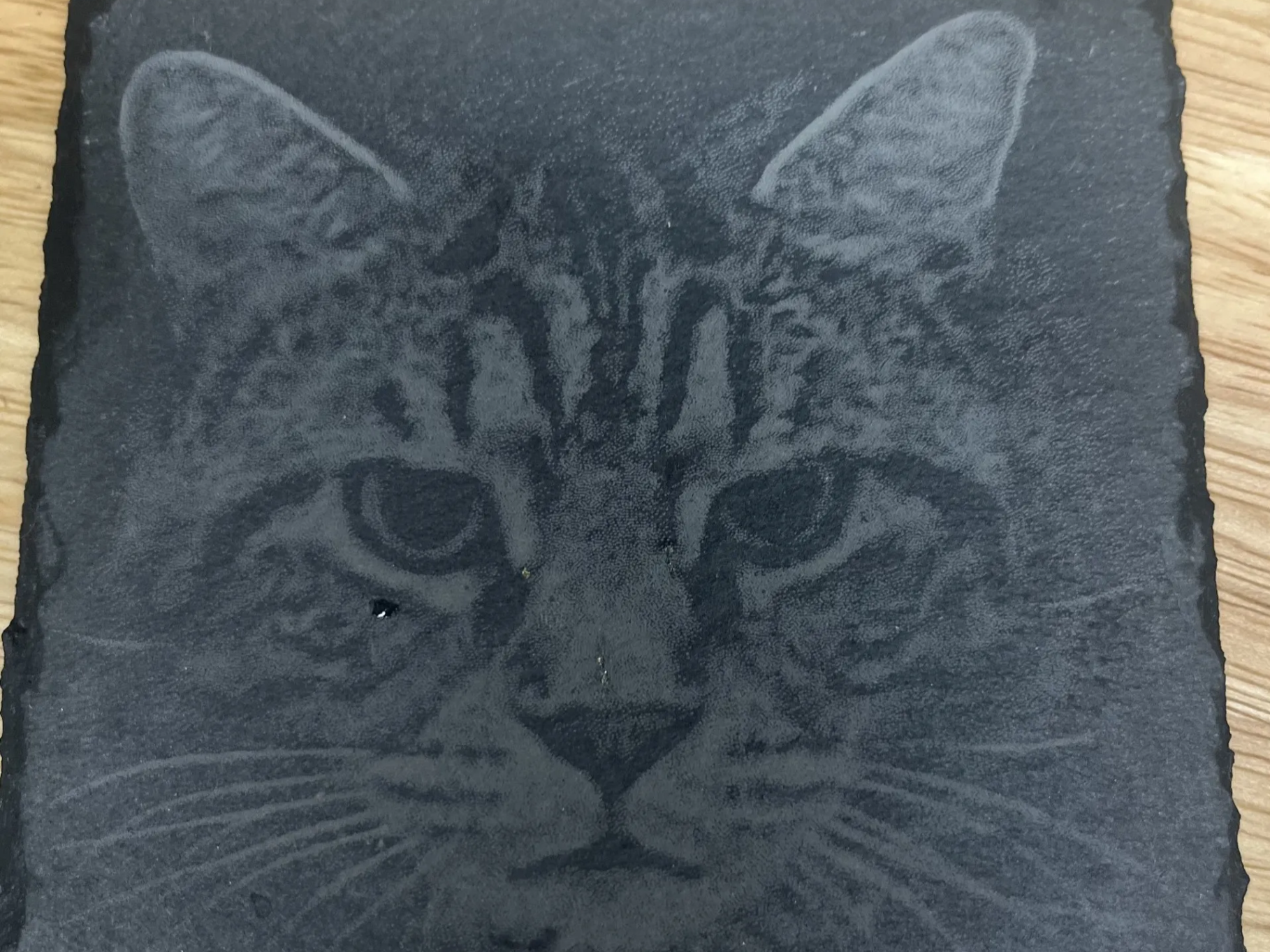 Black slate coaster engraved with a cat design