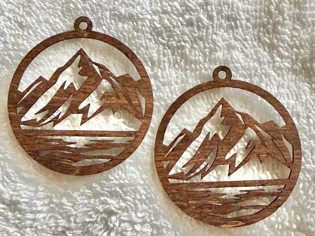 Pair of wooden mountain scene ornaments that double as pendants