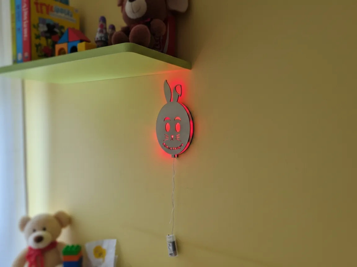 Wooden wall lamp with laser cut rabbit silhouette backlit on a wall