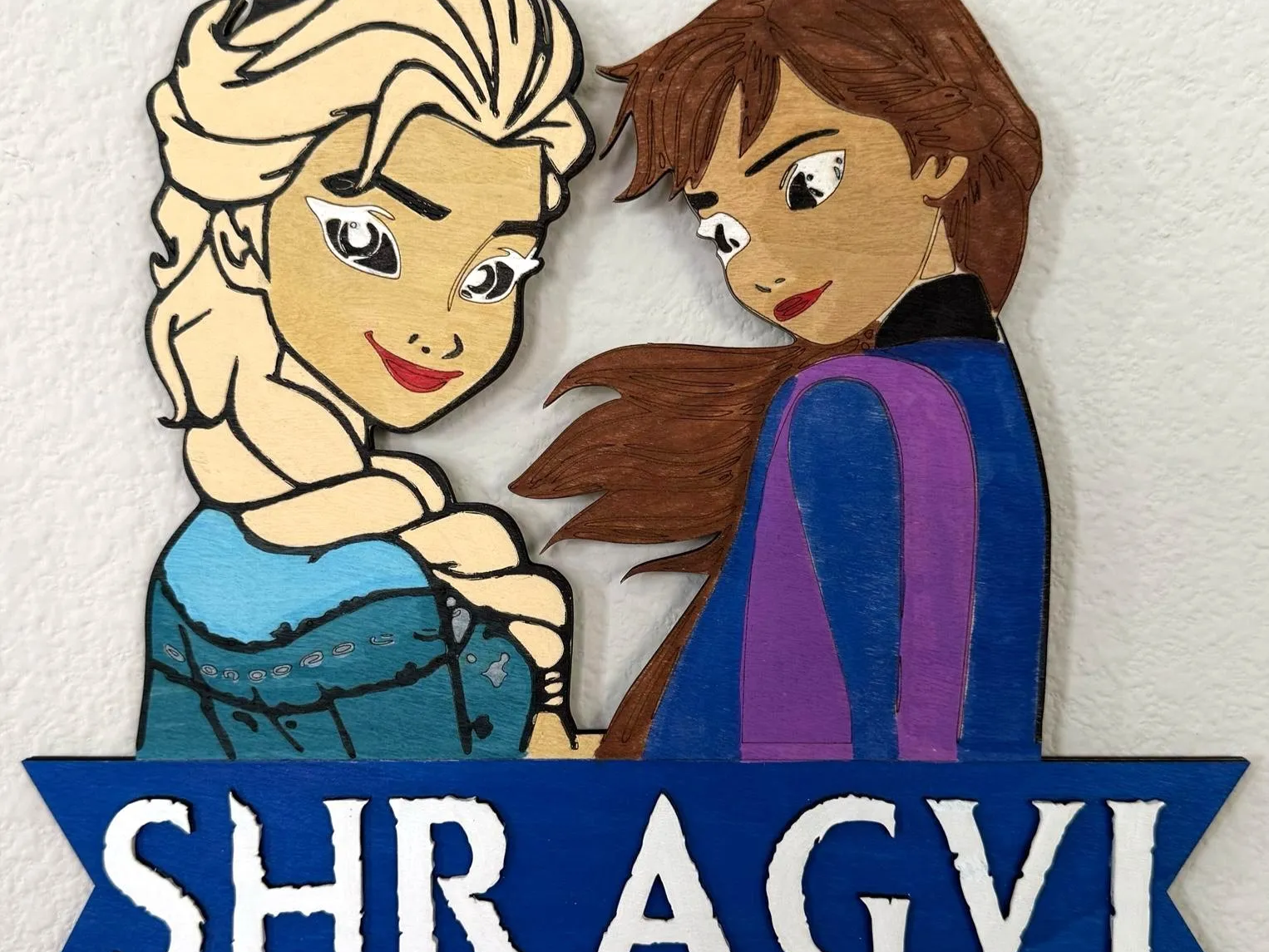 Wooden name board featuring cut Frozen character shapes