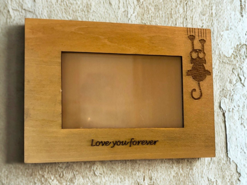 Wooden cat-shaped photo holder standing on a desk