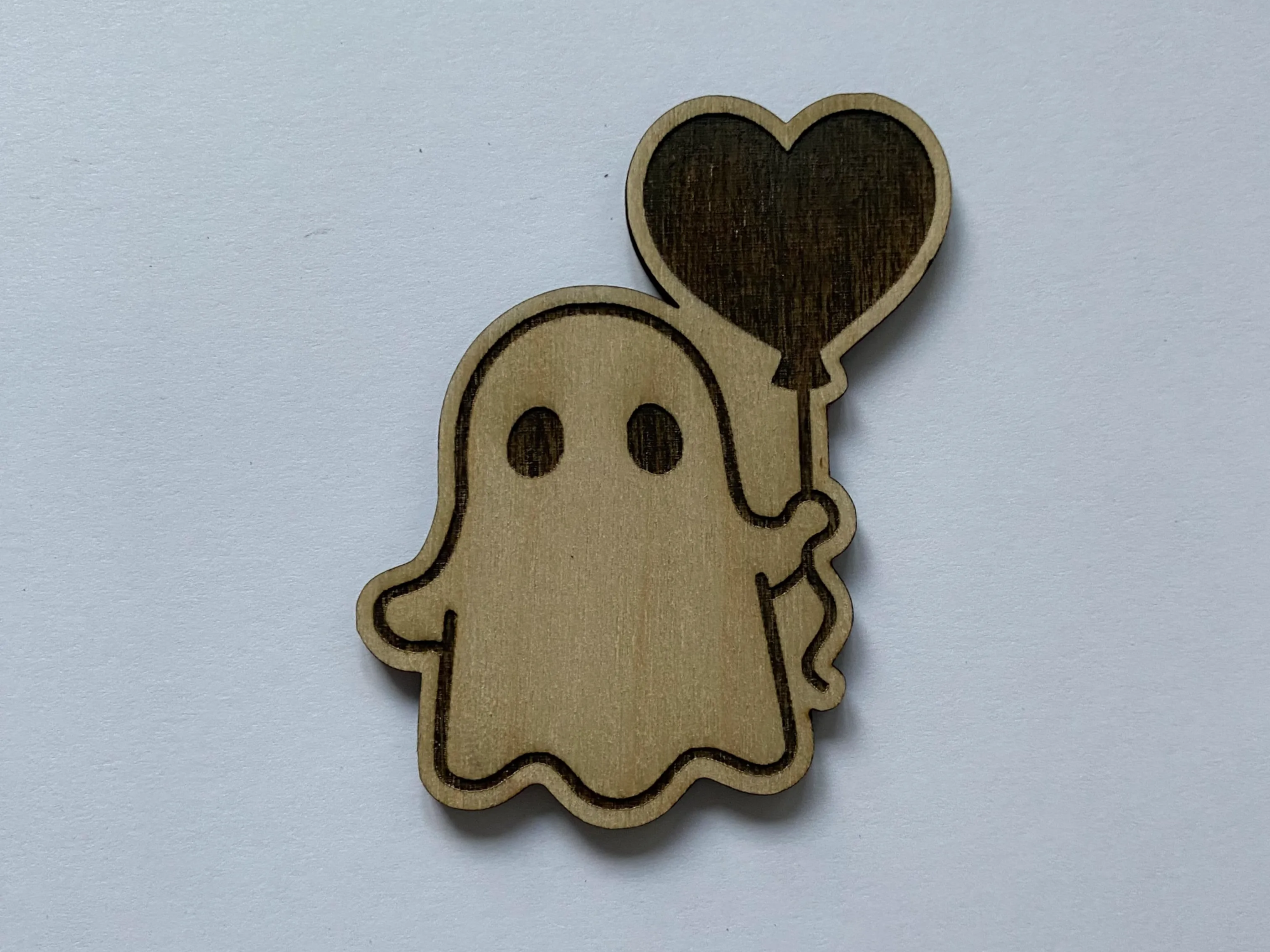 Cute wooden ghost ornament holding a heart shaped balloon
