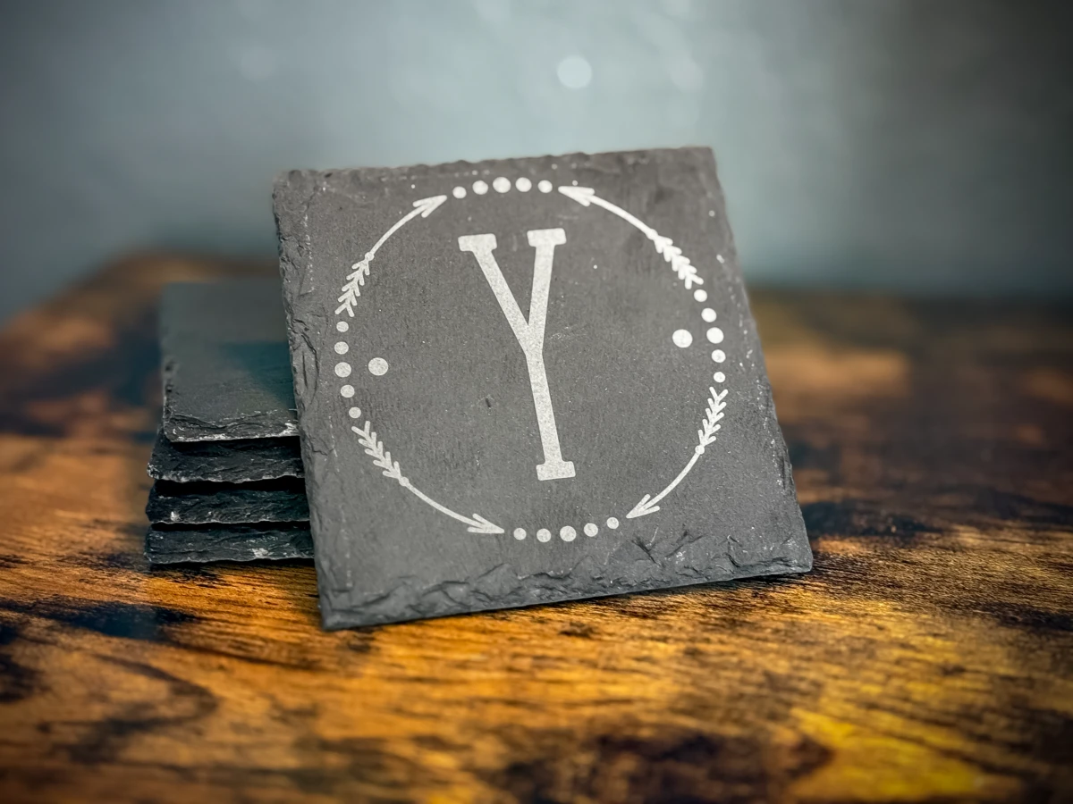 A single slate coaster engraved with a monogram