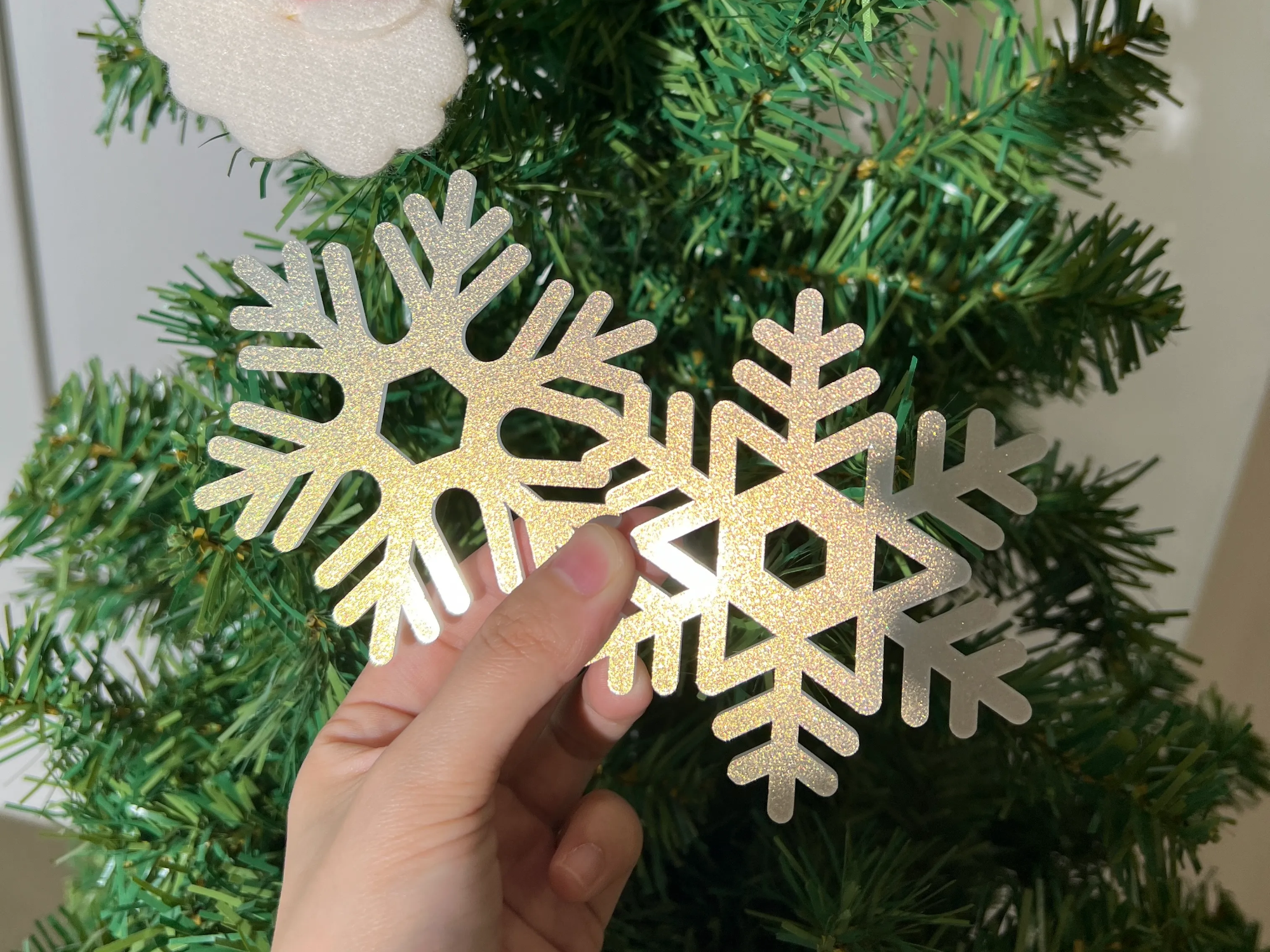 Fancy acrylic snowflake ornaments hanging in a Christmas window