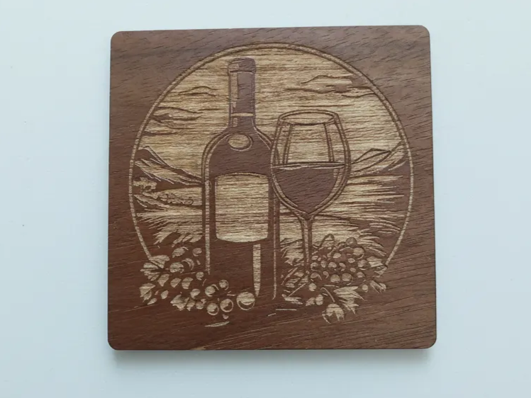Dessous-de-verre carré en noyer gravé d'une bouteille de vin, d'un verre à vin, de grappes de raisin et d'un paysage de vignoble
