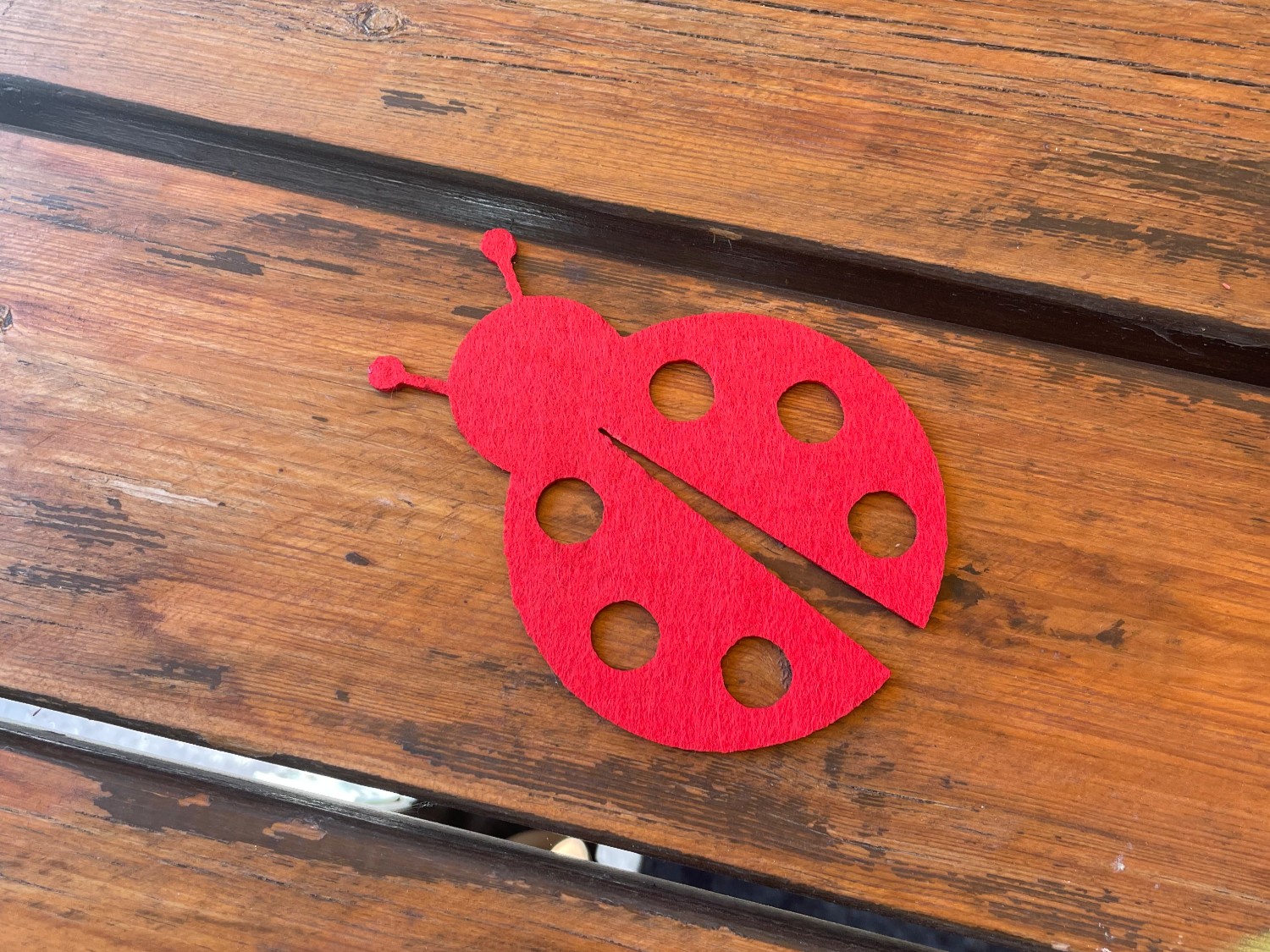 Red felt coaster shaped like a ladybug