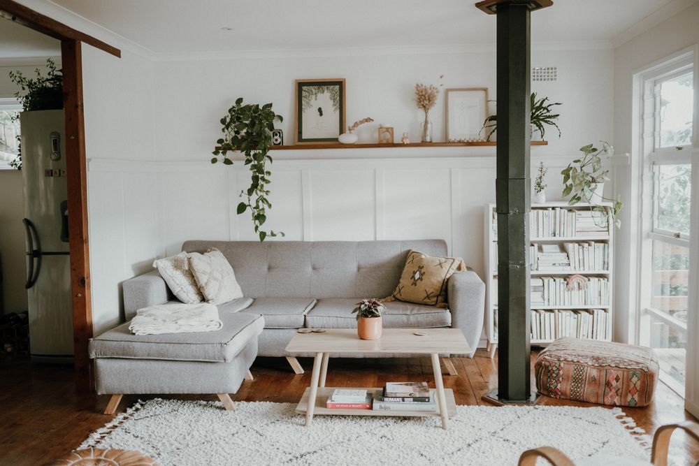 A bright Scandinavian living room with a pale sofa, white walls, and warm textures