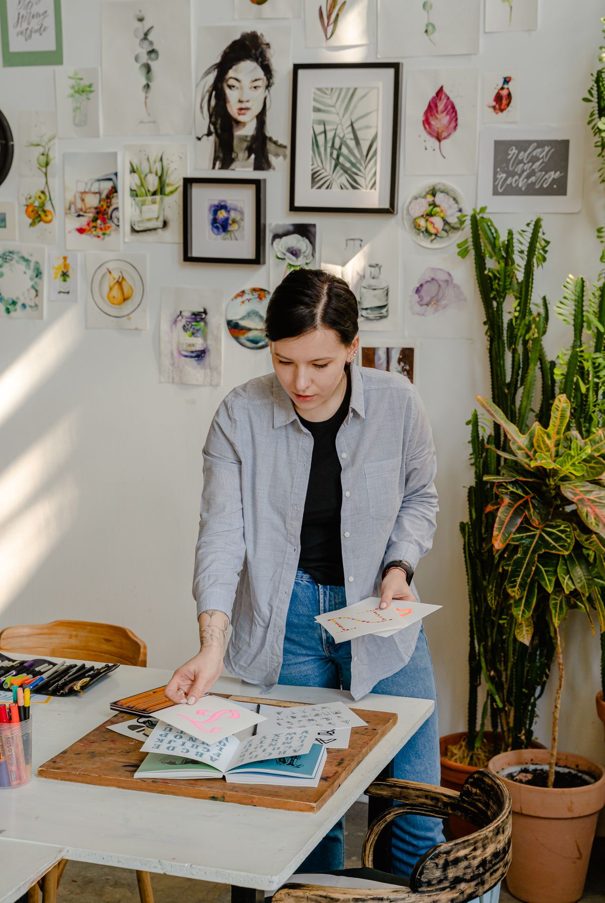 Eine Modedesignerin plant eine Kollektion und wählt Stoff und Designentwürfe aus